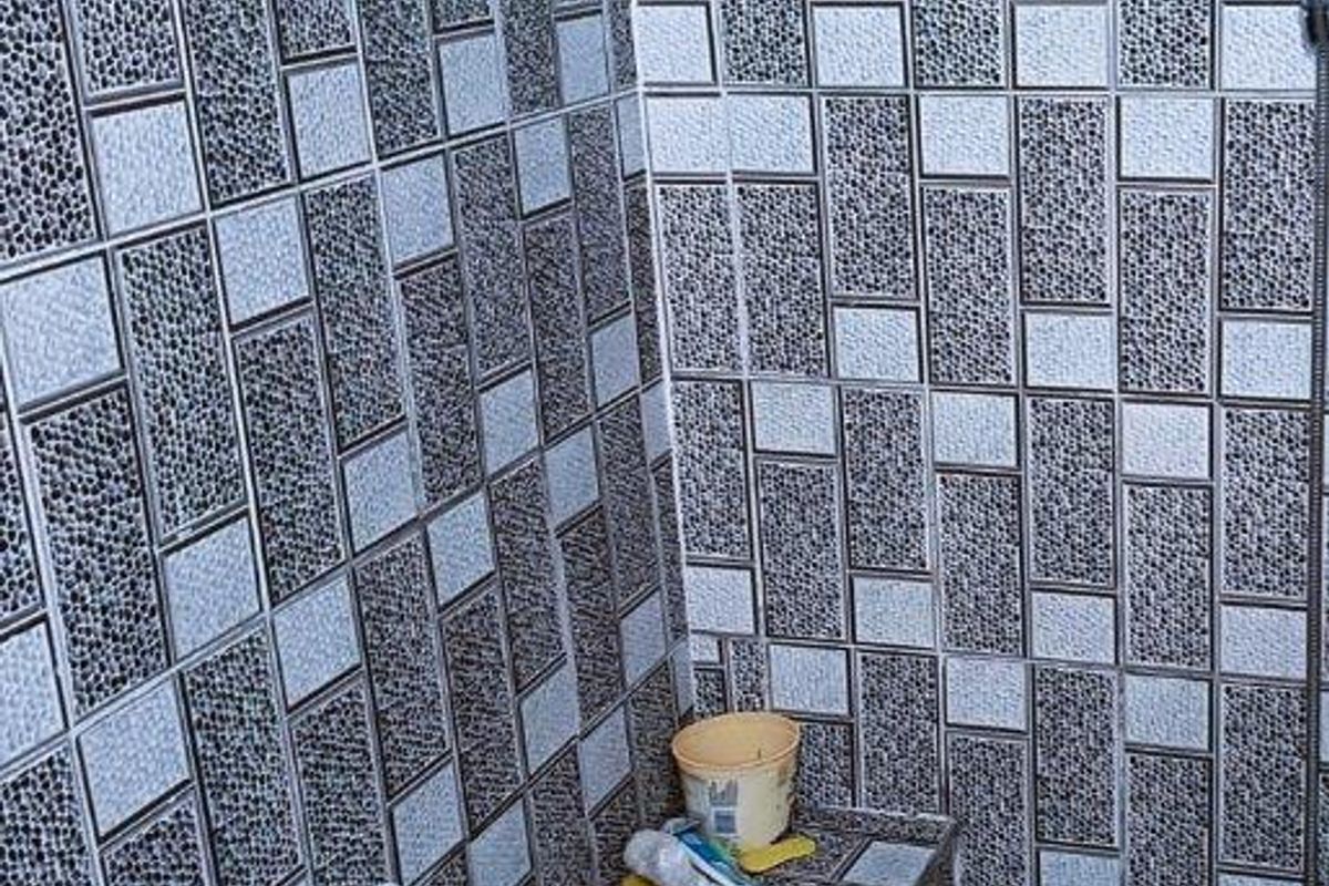 A tiled shower enclosure featuring a built-in tiled bench seat and a wall-mounted shower head.