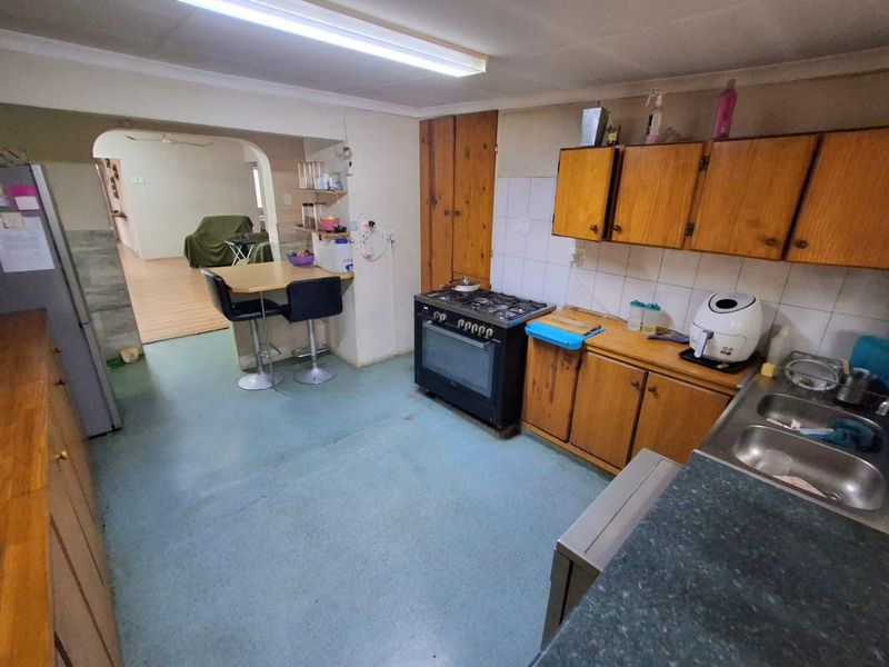 Functional kitchen featuring wooden cabinetry, gas stove, and a breakfast nook, opening into the adjacent living area.