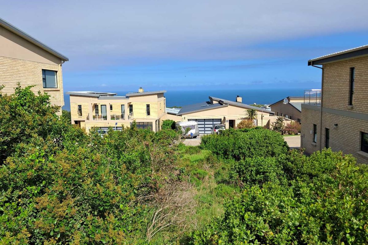 A scenic elevated view overlooking the surrounding residential estate with a clear horizon line and ocean backdrop.