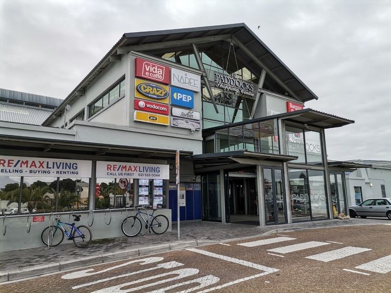 Front elevation of The Paddocks Shopping Centre featuring modern architectural design, glass facade, and prominent commercial signage.