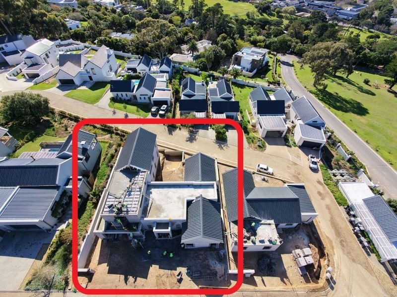 Aerial view of a residential property currently under construction, showing the roof structure and site development within a suburban estate.