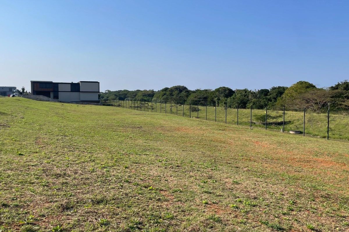 A spacious vacant residential plot featuring established perimeter electric fencing and a clear view of the surrounding landscape.
