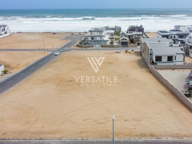Aerial view of a vacant residential plot situated in a coastal estate, offering proximity to the ocean and established neighborhood infrastructure.