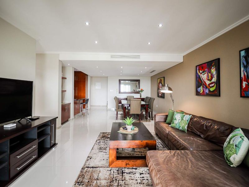 Spacious open-plan living and dining area featuring polished porcelain tiles, recessed lighting, and integrated climate control, creating a bright and modern living environment.