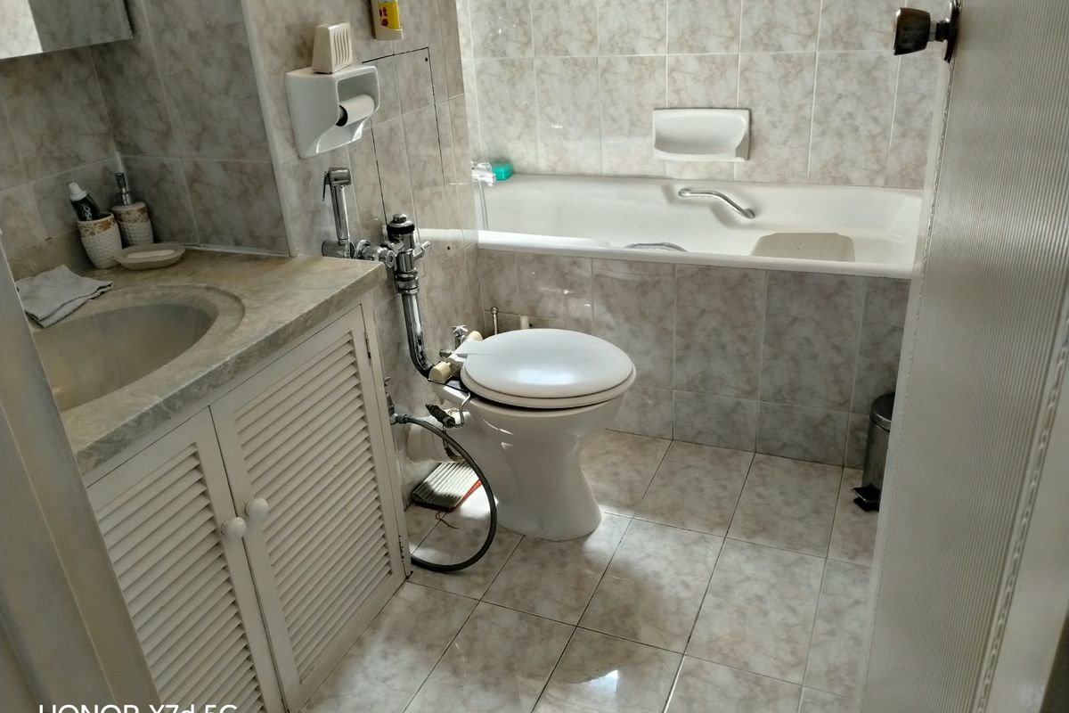 A functional bathroom featuring a built-in vanity, integrated sink, toilet, and a bathtub with tiled wall and floor finishes.