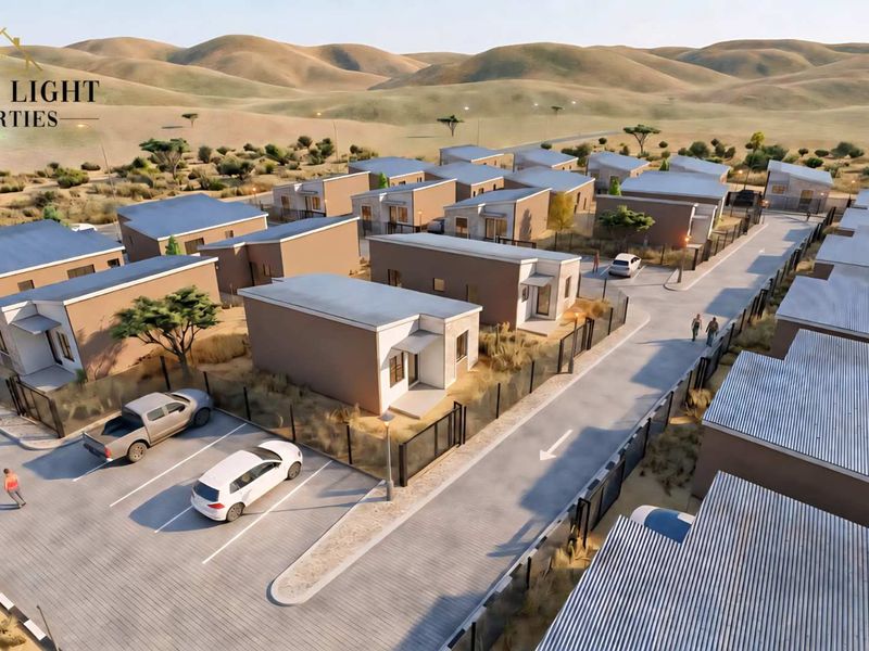 An aerial perspective of a modern townhouse development featuring paved roads, designated parking areas, and perimeter fencing within a landscaped estate.