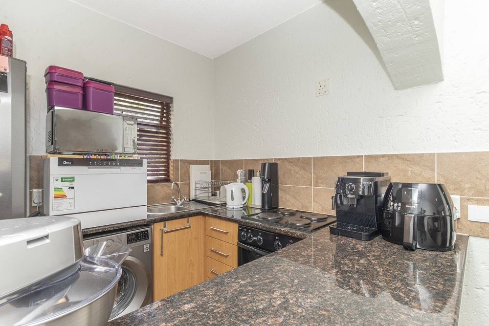 Kitchen with counter space and fridge, washing machine and top of counter dishwasher