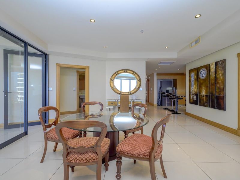 Spacious open-plan living area featuring neutral tiled flooring, recessed downlighting, and timber door frames, providing a bright and versatile space.