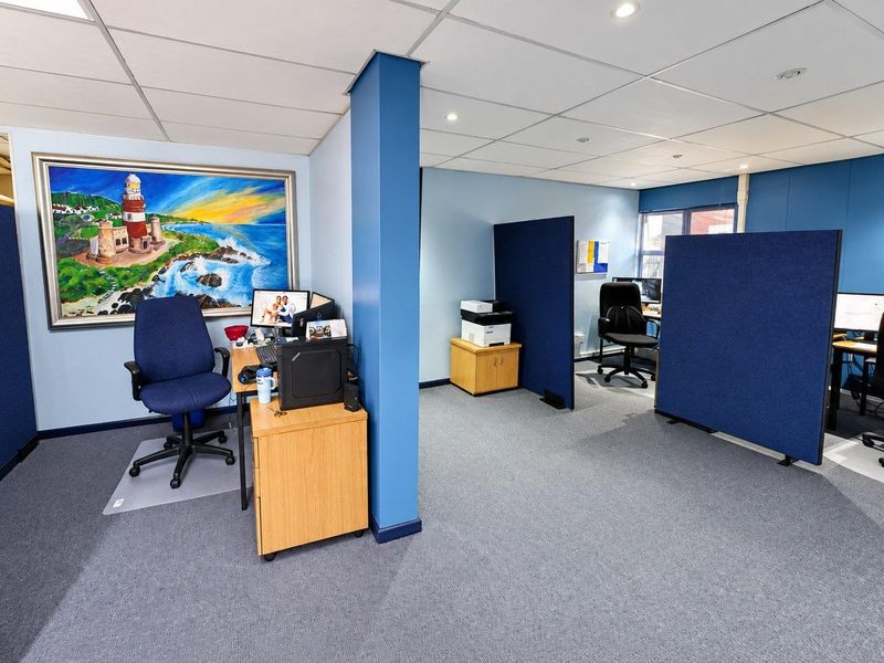 Open-plan office space featuring suspended ceilings, recessed lighting, and modular partition walls, providing a functional and professional work environment.