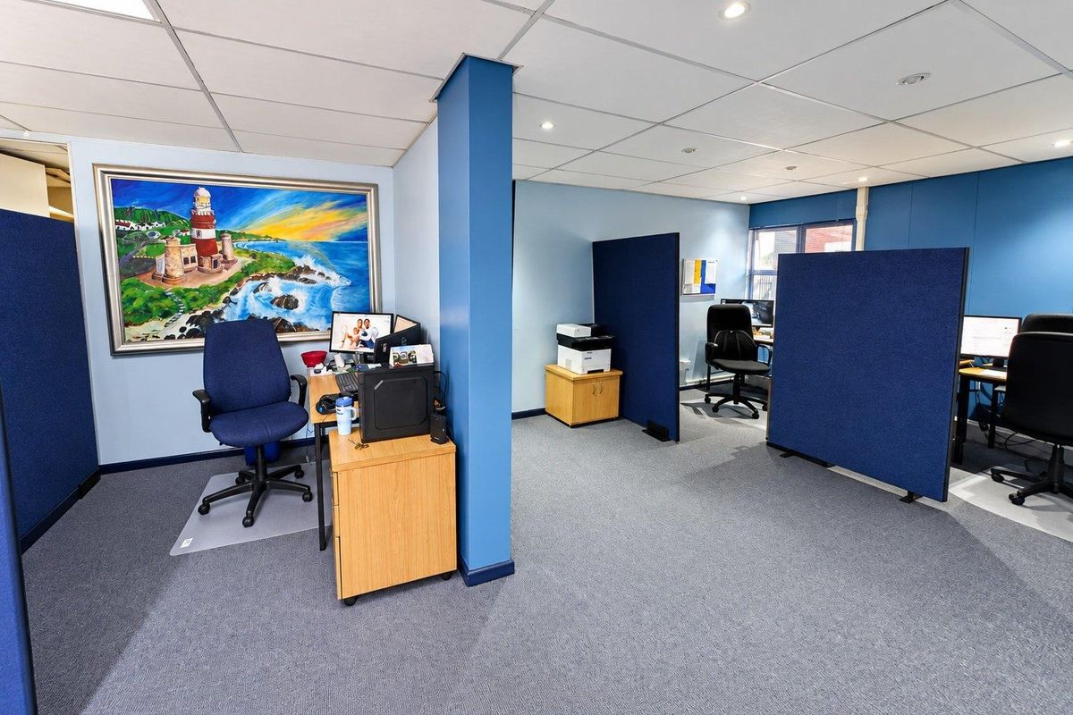 Open-plan office space featuring suspended ceilings, recessed lighting, and modular partition walls, providing a functional and professional work environment.