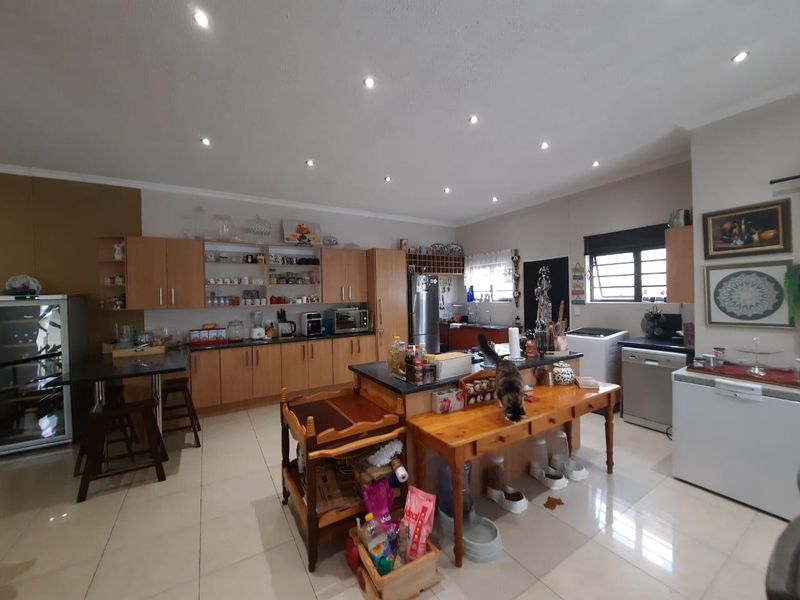 Spacious kitchen featuring extensive built-in cabinetry, granite countertops, tiled flooring, and recessed lighting, offering a functional layout with ample storage and workspace.
