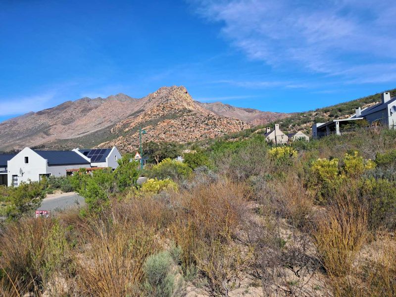 A scenic view of the surrounding mountain landscape and natural vegetation, showcasing the natural beauty of the residential estate.