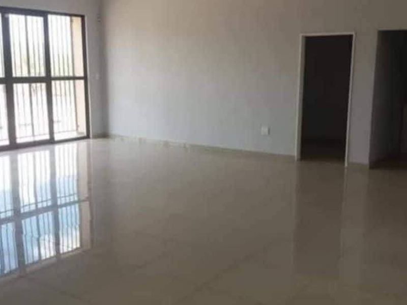 Spacious open-plan industrial area featuring polished tiled flooring and large glass sliding doors with integrated security bars, offering a clean and versatile workspace.
