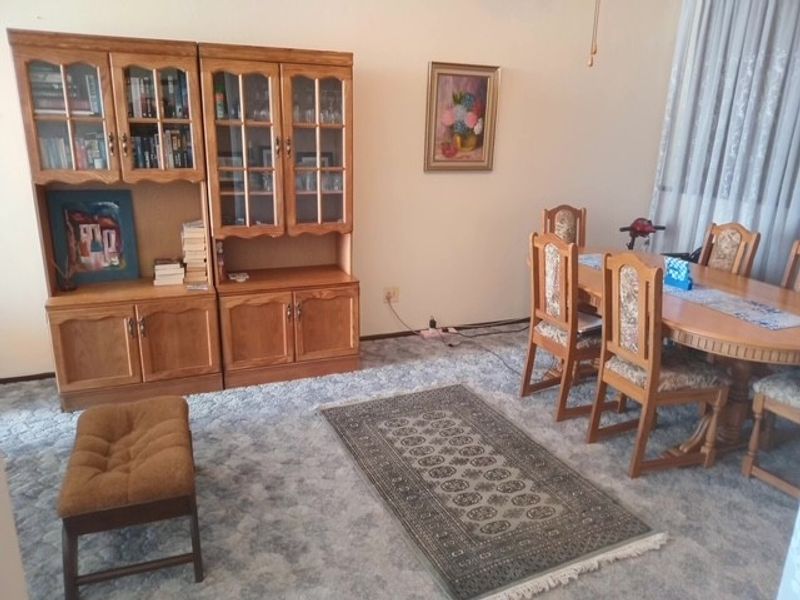 A dining room area featuring carpeted flooring and neutral wall finishes, providing a functional space for meals and gatherings.