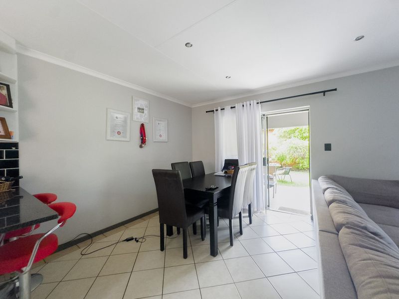 Open plan living and dining area featuring tiled flooring, recessed lighting, and direct access to the rear garden through a sliding glass door.