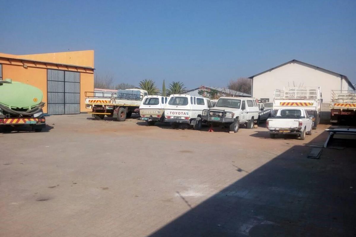 Spacious industrial yard area featuring paved ground, surrounding warehouse structures, and ample open space for vehicle parking or operational activities.