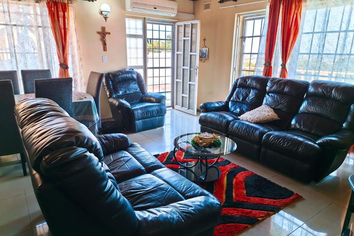 A living room featuring tiled flooring, a timber ceiling, and a split-system air conditioner, with direct access to an outdoor area via a security gate.