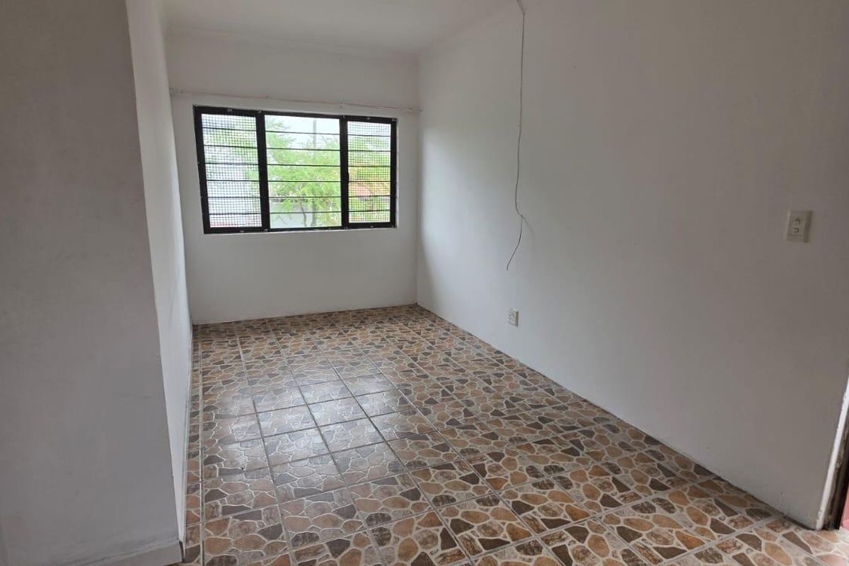 An empty bedroom featuring tiled flooring and windows with security bars. The space requires minor electrical repairs and cosmetic updates.