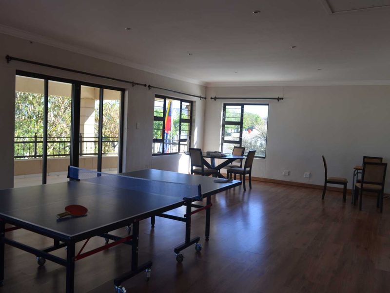 Spacious living area featuring laminate flooring, recessed lighting, and large sliding doors opening onto a balcony, providing ample natural light.