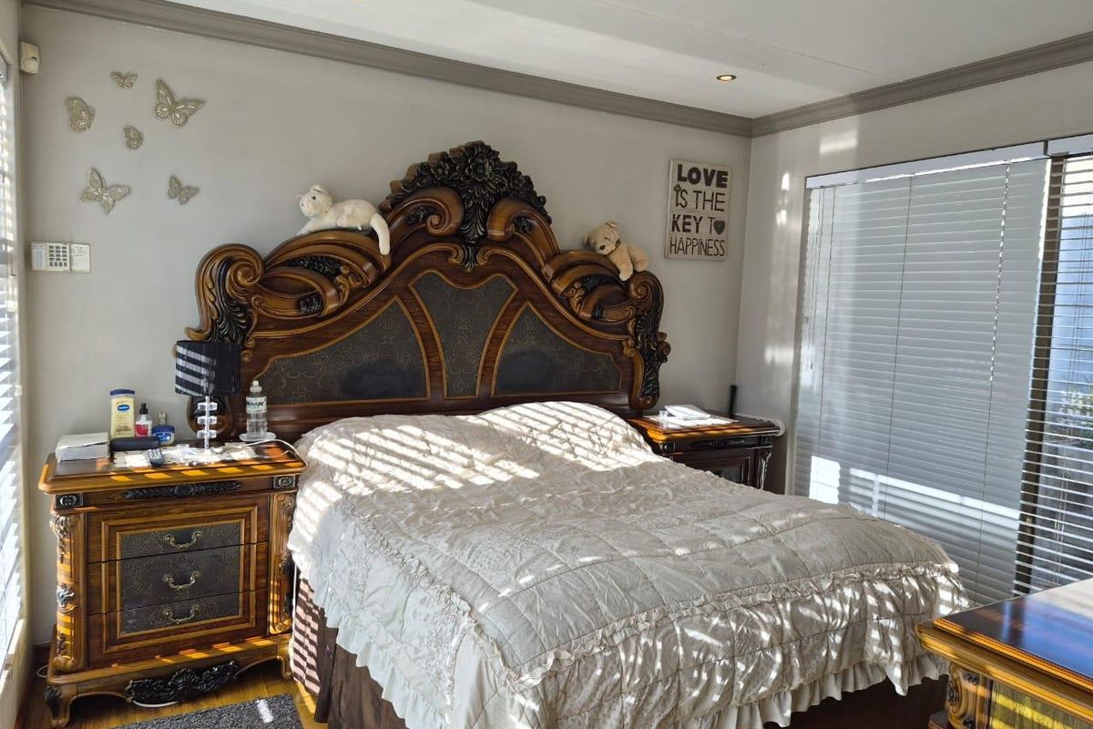 A well-maintained bedroom featuring recessed ceiling lighting, crown molding, and horizontal window blinds.