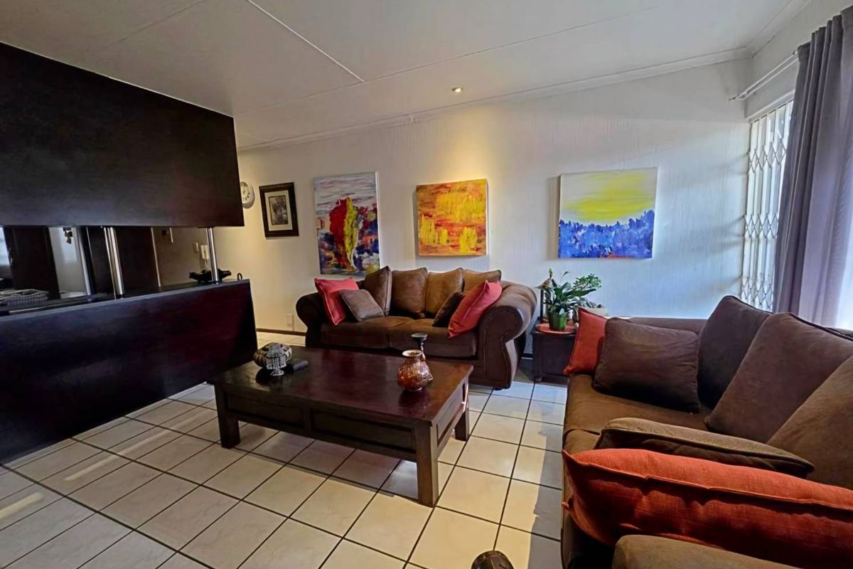 A living room featuring tiled flooring and a built-in dark wood fireplace surround, providing a cozy and functional space.