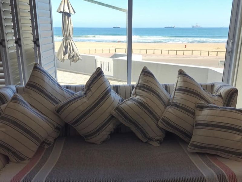 A bright interior space featuring large sliding glass doors that provide an expansive, unobstructed view of the ocean and beach.