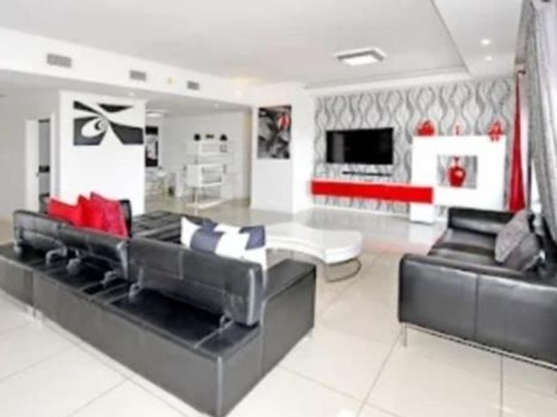 Spacious open-plan living area featuring large format floor tiles, recessed ceiling lighting, and integrated air conditioning vents.