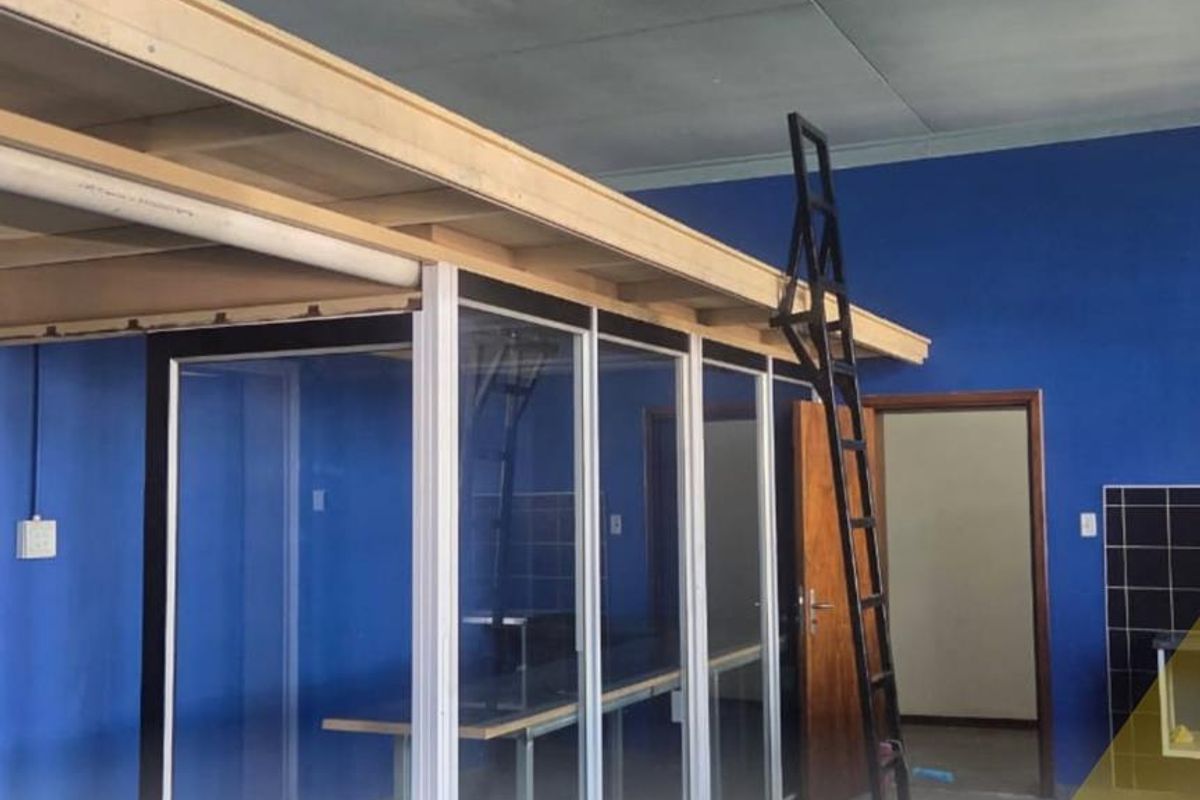 An open-plan office space featuring a mezzanine level, glass partitions, and tiled flooring, suitable for a versatile business environment.