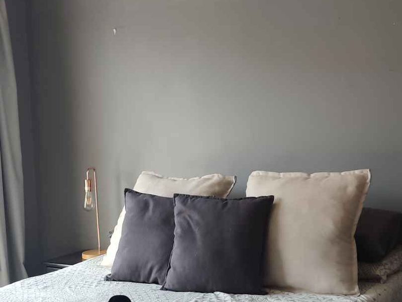 A bedroom featuring a ceiling fan and grey painted walls, requiring minor cosmetic touch-ups to improve the overall finish.