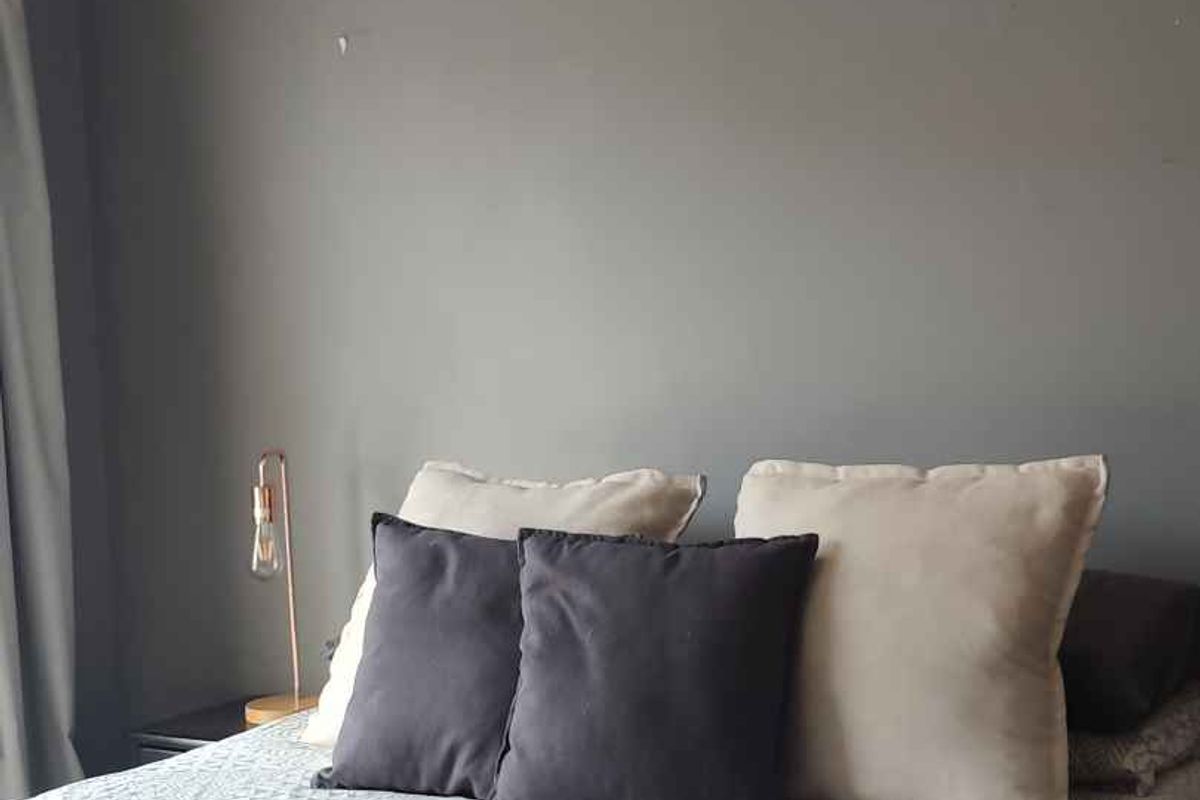 A bedroom featuring a ceiling fan and grey painted walls, requiring minor cosmetic touch-ups to improve the overall finish.