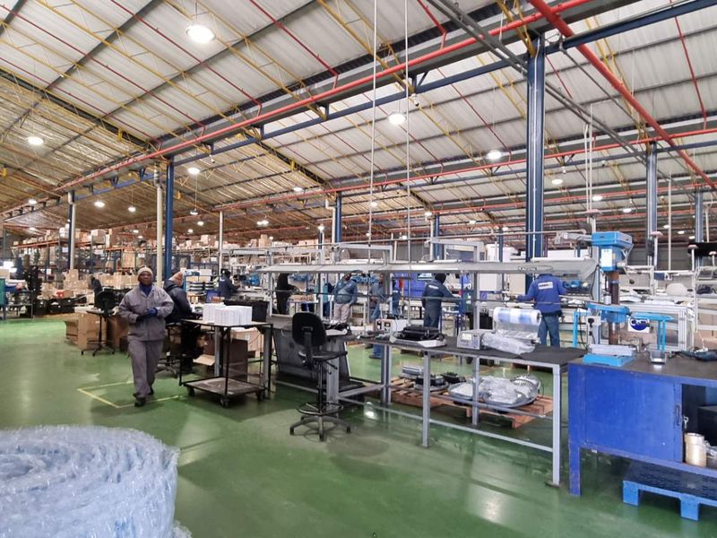 Spacious industrial warehouse facility featuring high-clearance steel truss roofing, polished concrete flooring, and integrated overhead lighting systems suitable for manufacturing or logistics operations.
