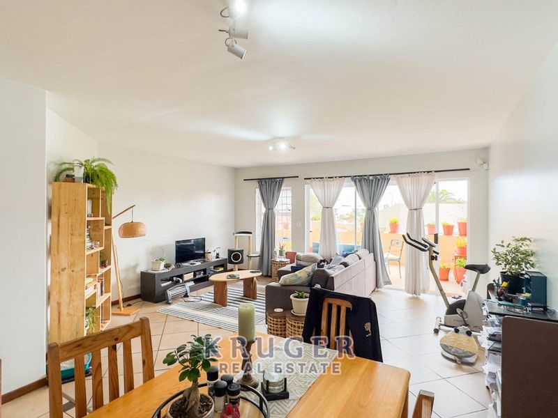 Spacious open-plan living area featuring tiled flooring and large sliding glass doors that provide access to an outdoor balcony space.