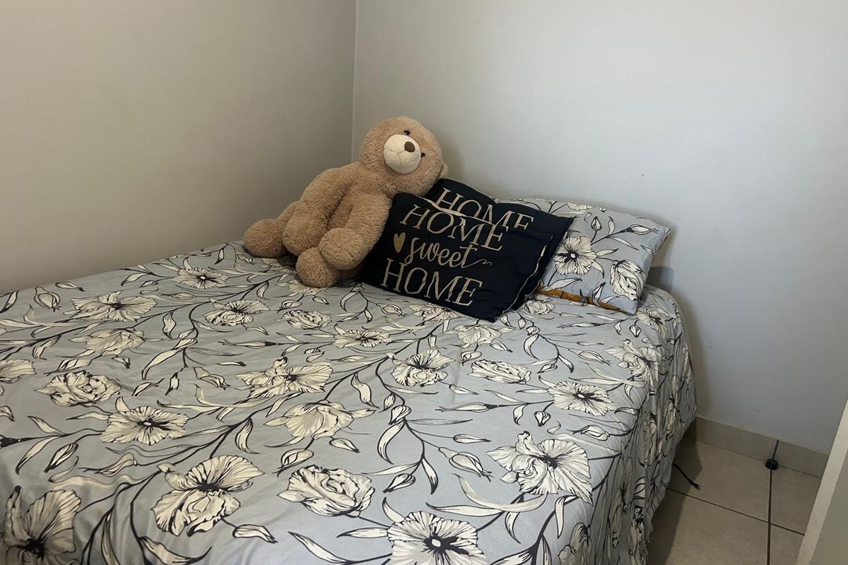 A bedroom featuring neutral wall finishes and tiled flooring, providing a simple and functional living space.