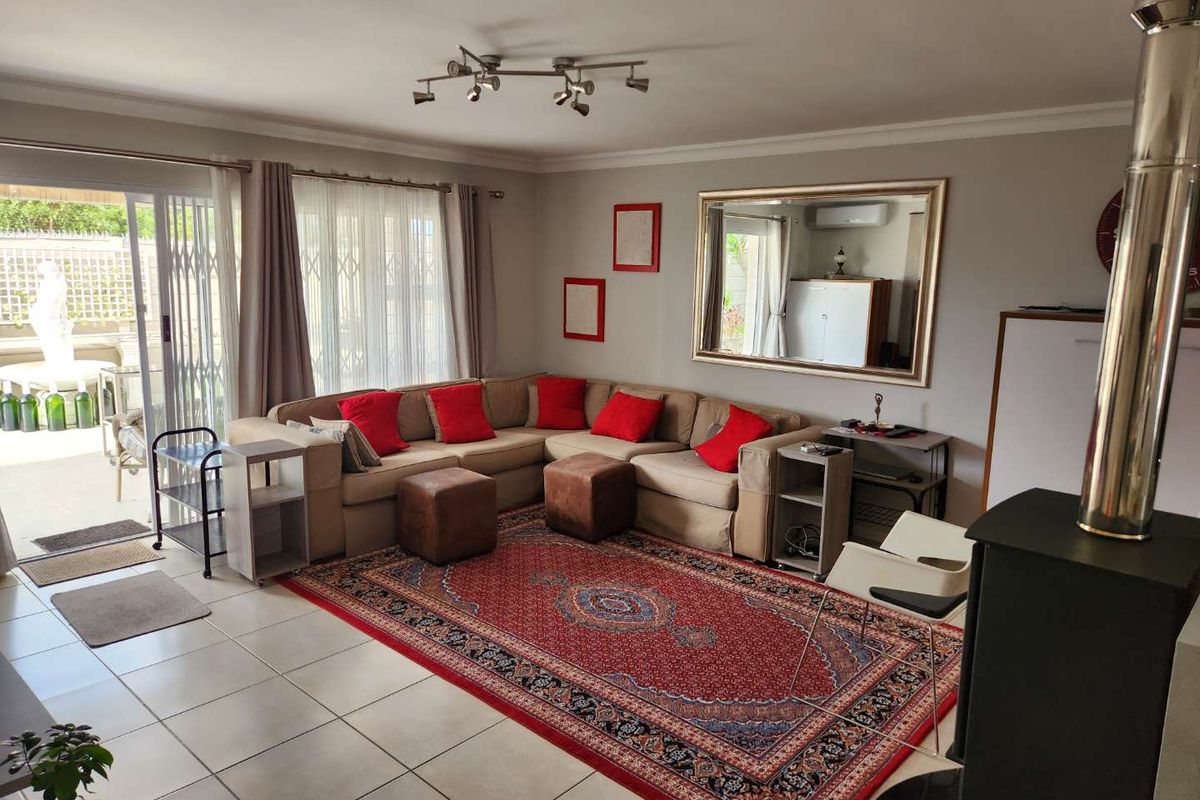Spacious living room featuring tiled flooring, a built-in fireplace, and large sliding glass doors providing direct access to the outdoor patio area.
