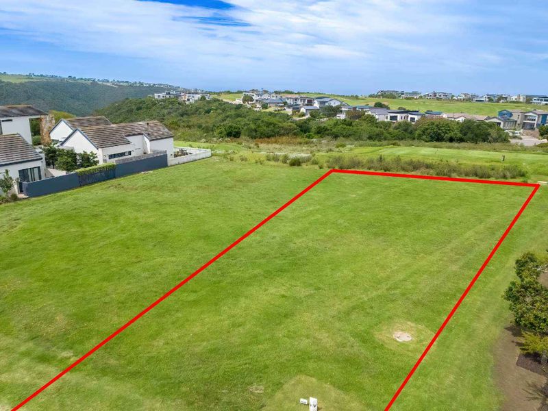 An aerial view of a vacant residential plot of land with clear boundary markings, situated in a developed estate.
