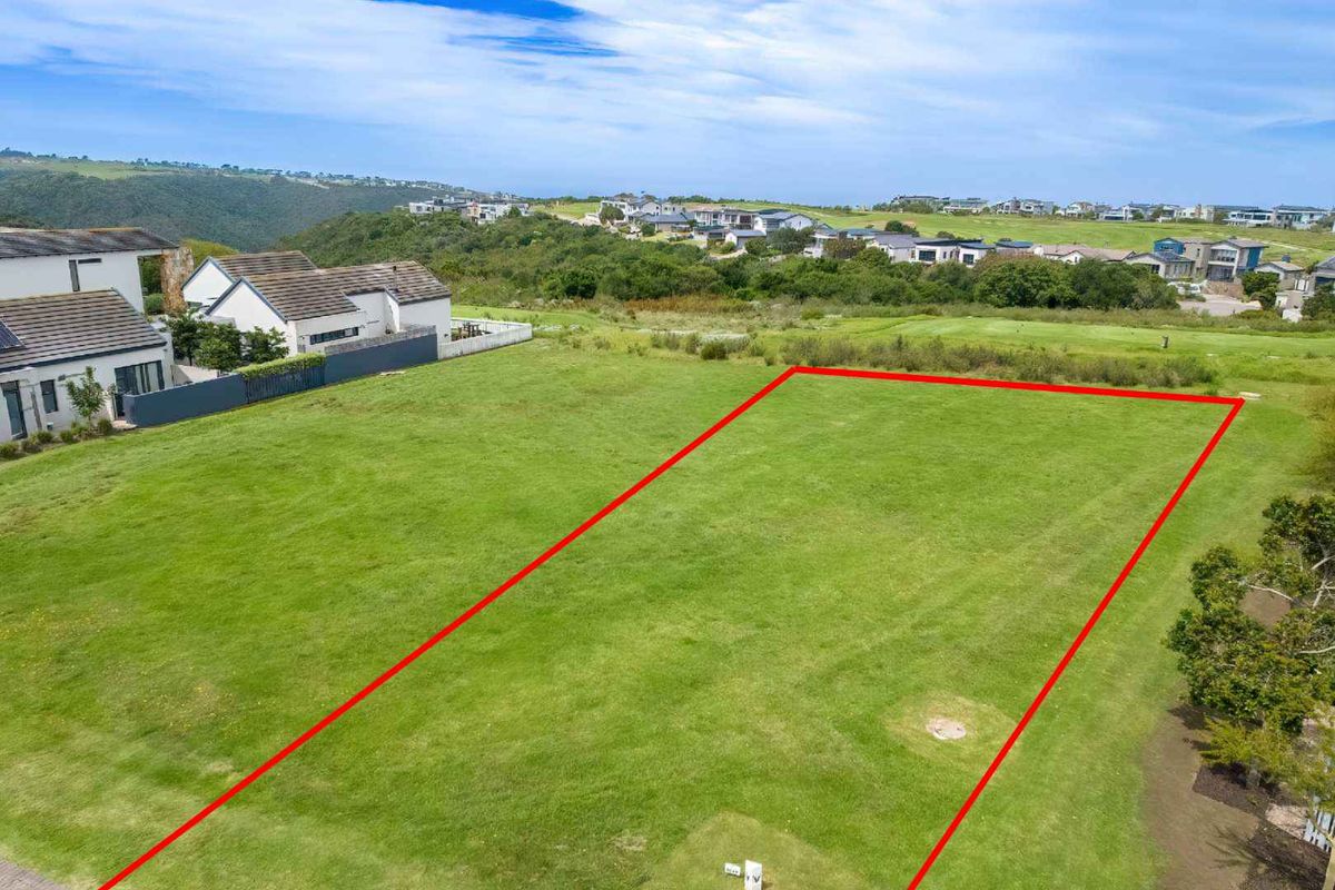 An aerial view of a vacant residential plot of land with clear boundary markings, situated in a developed estate.