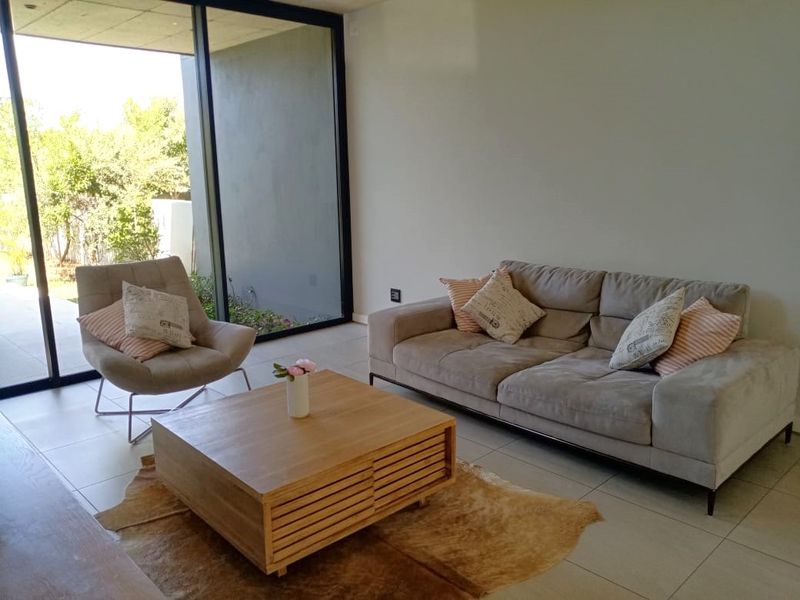 A bright living room featuring large sliding glass doors that provide seamless access to the outdoor area and ample natural light.