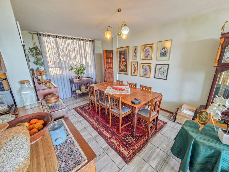 A dining room featuring tiled flooring and a central ceiling light fixture, providing a functional space for family meals.