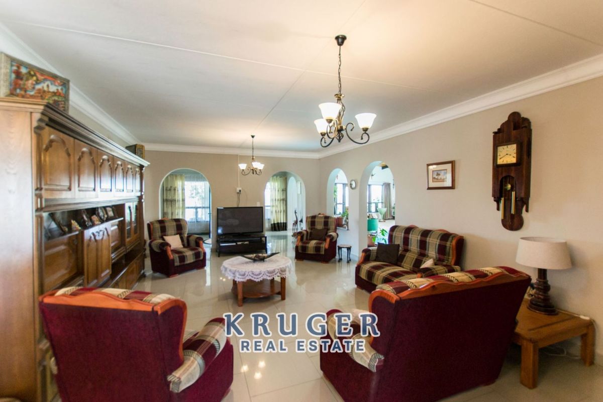 Spacious living room featuring tiled flooring, decorative archways, and classic ceiling cornices, providing a comfortable and well-defined area for relaxation.