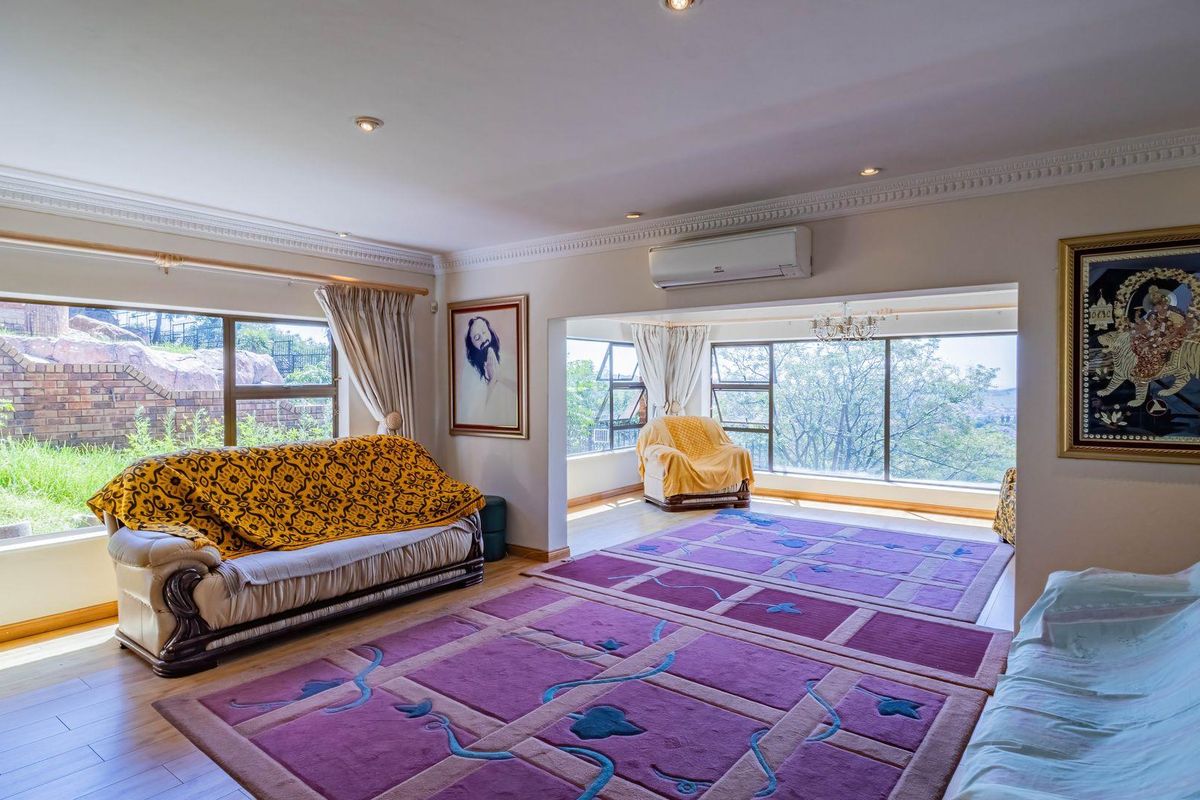 Spacious living area featuring large windows, recessed ceiling lighting, crown molding, and a wall-mounted air conditioning unit.