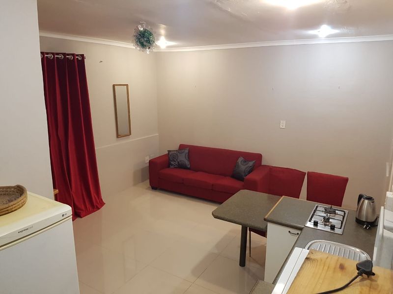 Open plan living and kitchen area featuring tiled flooring, built-in gas hob, and integrated sink, offering a functional layout for modern living.