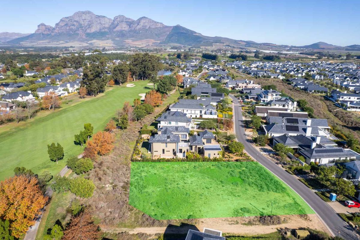 An aerial view of a vacant residential plot situated in a prime estate, featuring direct golf course frontage and convenient street access.