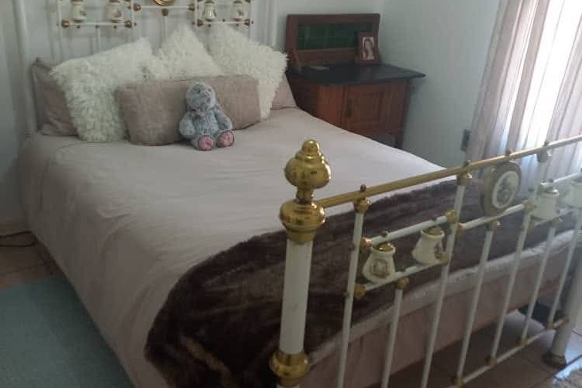 A bedroom featuring tiled flooring and a window with curtains, providing a functional and comfortable living space.