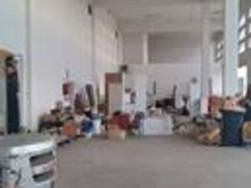 Spacious industrial utility area featuring high ceilings, concrete flooring, and exposed structural columns, suitable for storage or workshop operations.