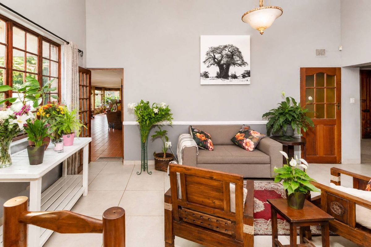 A bright living room featuring tiled floors, high vaulted ceilings, and classic wooden door frames, offering a spacious and inviting atmosphere.