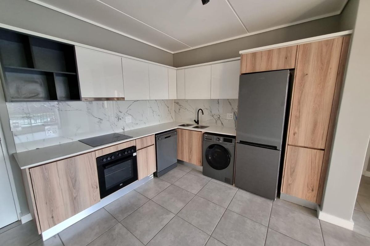 Modern kitchen featuring wood-tone and white cabinetry, marble-look splashback, integrated oven, electric cooktop, and tiled flooring in a clean, contemporary layout.