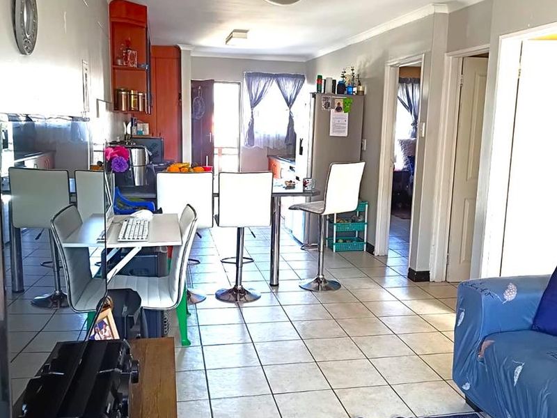Open-plan living and kitchen area featuring tiled flooring and built-in cabinetry, providing a functional layout for daily living.