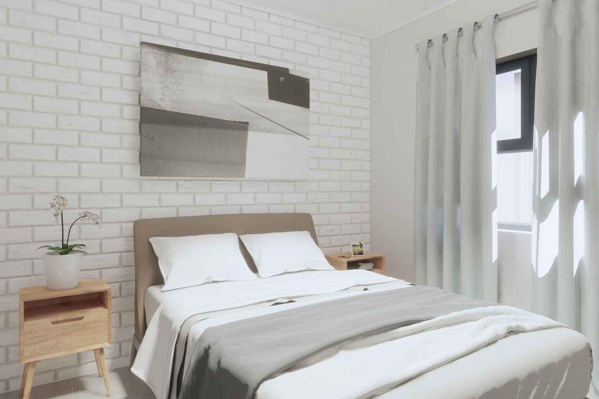 A bright and modern bedroom featuring a white exposed brick accent wall and large window with natural light.
