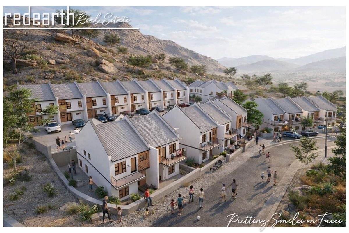An aerial perspective of a modern townhouse development featuring multiple units with pitched roofs, balconies, and integrated paved driveways in a scenic landscape.