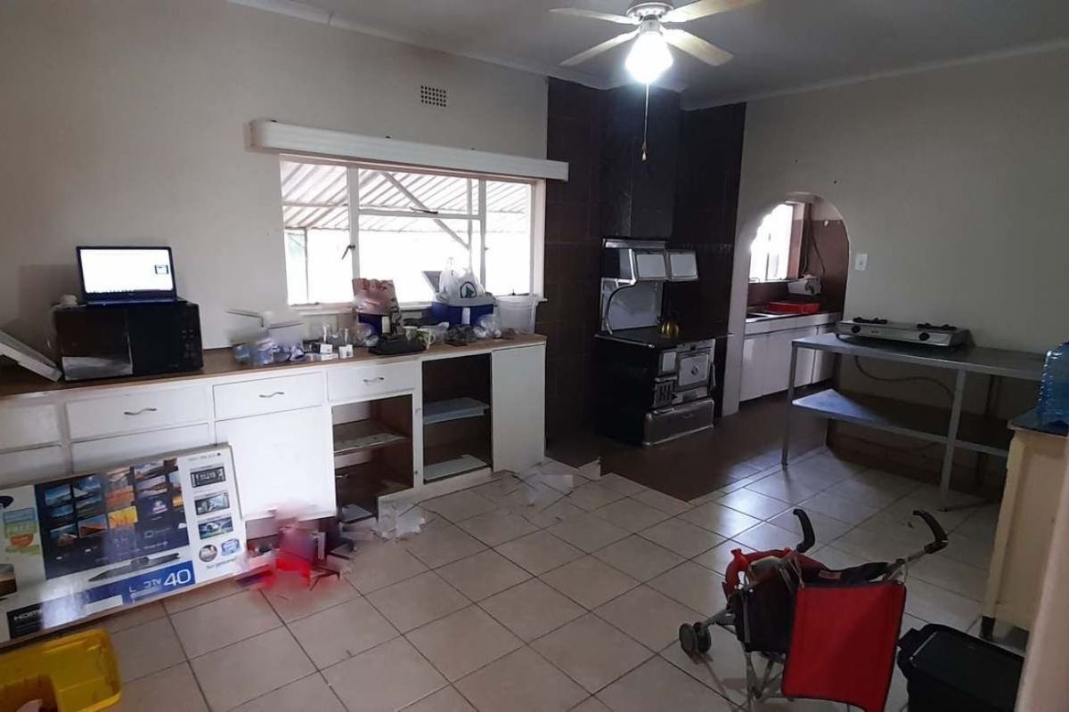 A functional kitchen area featuring tiled flooring, built-in cabinetry, and a dedicated cooking space with an integrated stove.